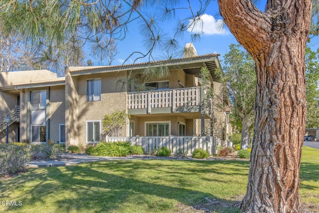 view of front of property with a front lawn and a balcony