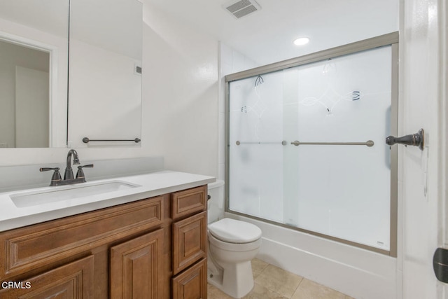 full bathroom with tile patterned flooring, bath / shower combo with glass door, vanity, and toilet