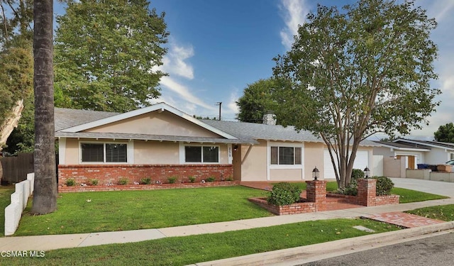 single story home featuring a garage and a front lawn