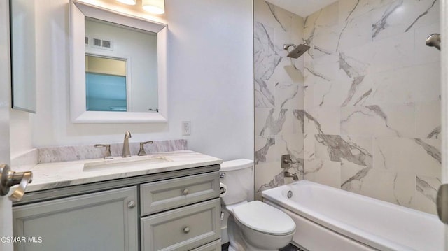 full bathroom featuring tiled shower / bath, vanity, and toilet