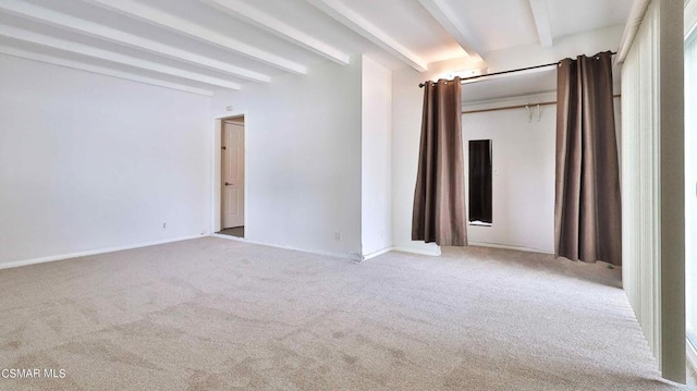 unfurnished bedroom with beamed ceiling and light colored carpet