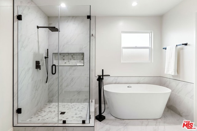 bathroom featuring tile walls and independent shower and bath