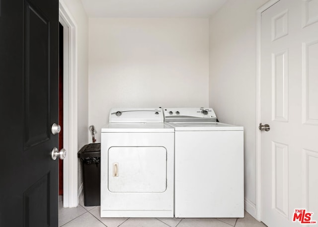 laundry area with washing machine and dryer and light tile patterned floors