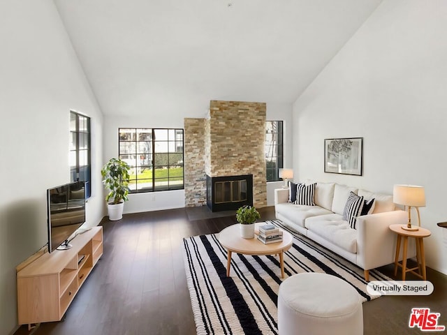 living room featuring a stone fireplace, dark hardwood / wood-style floors, and high vaulted ceiling