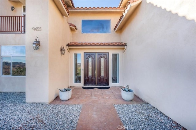 property entrance featuring stucco siding and a tiled roof