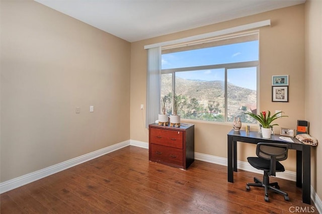 office space featuring dark wood finished floors, baseboards, and a mountain view