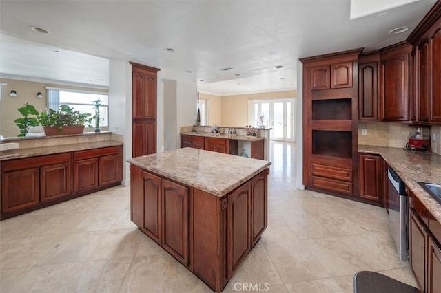 kitchen with light stone counters, light tile patterned floors, decorative backsplash, a kitchen island, and dishwasher