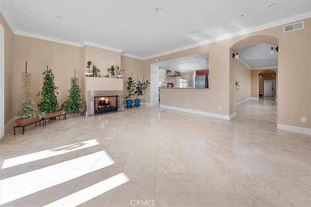 living room featuring a multi sided fireplace, crown molding, visible vents, baseboards, and arched walkways