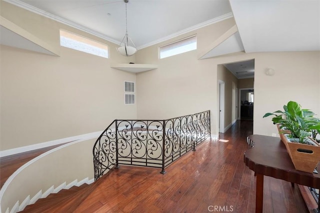 stairs featuring baseboards, visible vents, crown molding, and wood-type flooring