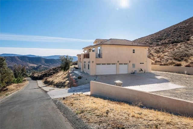 view of side of home with a garage and a mountain view