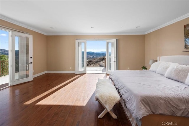 bedroom featuring dark hardwood / wood-style flooring, access to exterior, a mountain view, and ornamental molding