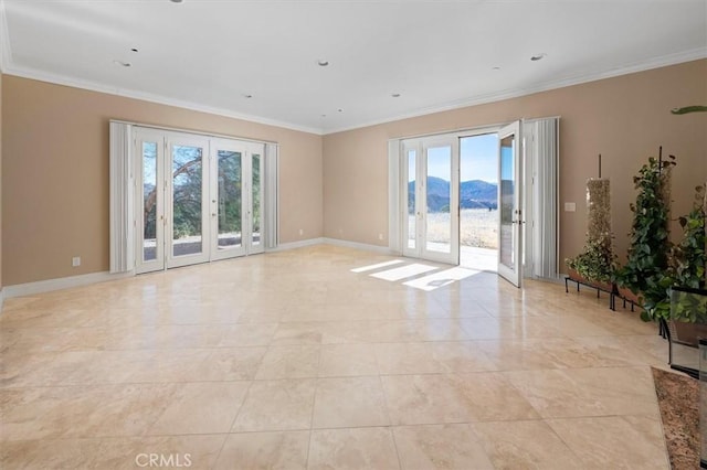 unfurnished room with crown molding, a mountain view, a healthy amount of sunlight, and french doors