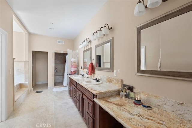 bathroom with a tile shower and vanity