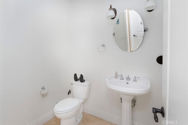 bathroom with toilet, tile patterned flooring, and baseboards