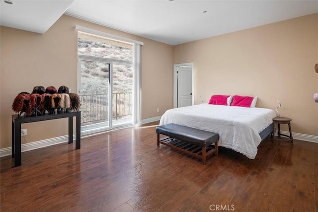 bedroom with wood finished floors, access to exterior, and baseboards
