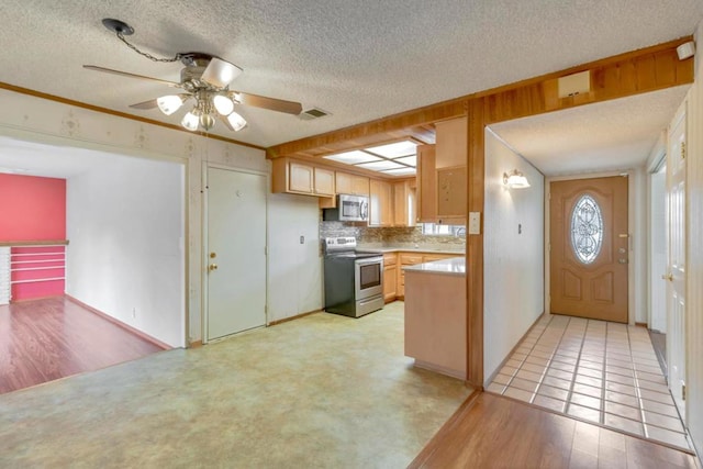 kitchen featuring light brown cabinetry, a textured ceiling, light wood-type flooring, appliances with stainless steel finishes, and backsplash