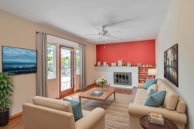 living room featuring ceiling fan, a fireplace, and hardwood / wood-style floors