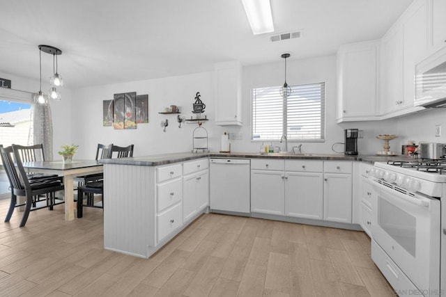 kitchen with white cabinetry, white appliances, kitchen peninsula, and pendant lighting