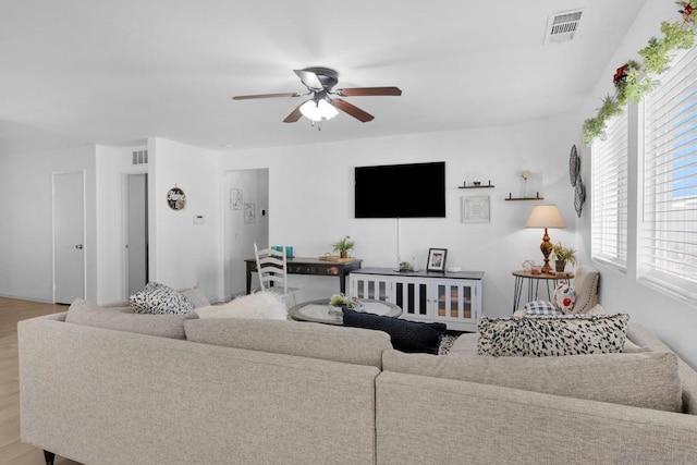 living room with light hardwood / wood-style flooring and ceiling fan