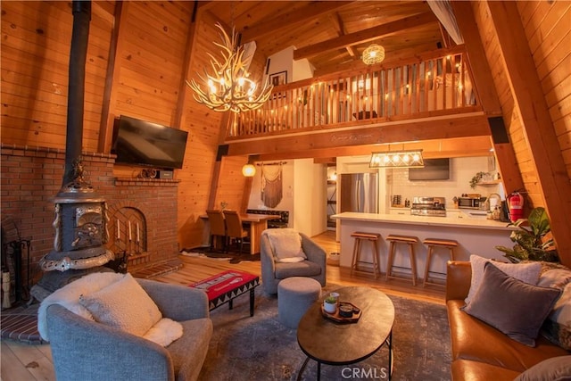 living room featuring wooden ceiling, a notable chandelier, wood walls, wood finished floors, and a wood stove