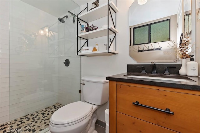 bathroom featuring tiled shower, vanity, and toilet