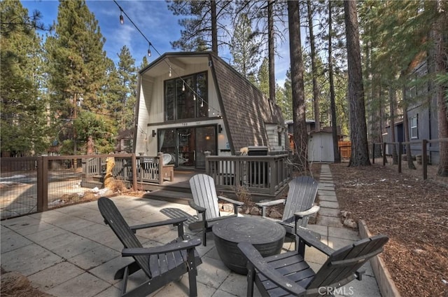 view of patio featuring a storage unit, an outdoor structure, and fence