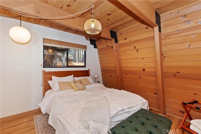 bedroom featuring beamed ceiling, wooden walls, hardwood / wood-style floors, and wood ceiling