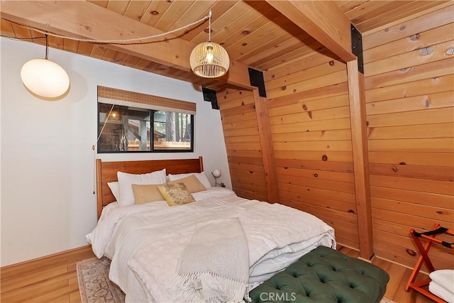 bedroom featuring wood ceiling, wood walls, wood finished floors, and beam ceiling