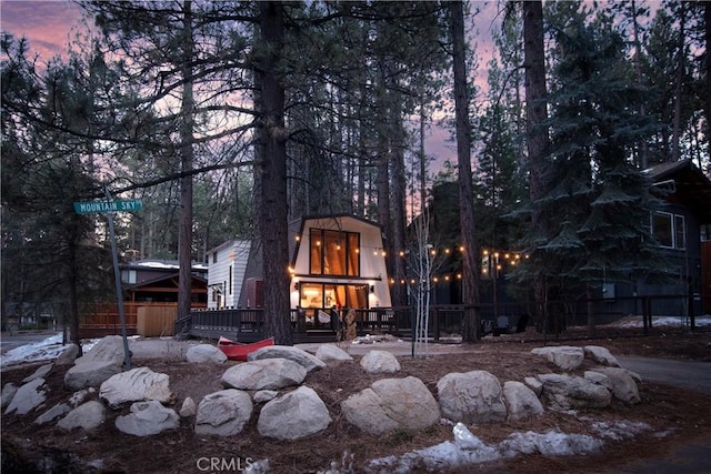 back house at dusk with a deck