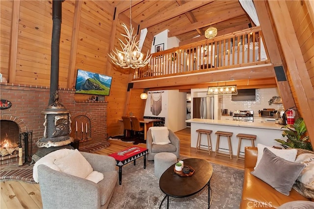 living room featuring high vaulted ceiling, wood-type flooring, a wood stove, wooden ceiling, and beam ceiling