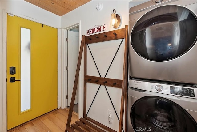 washroom featuring stacked washer / dryer and light hardwood / wood-style flooring