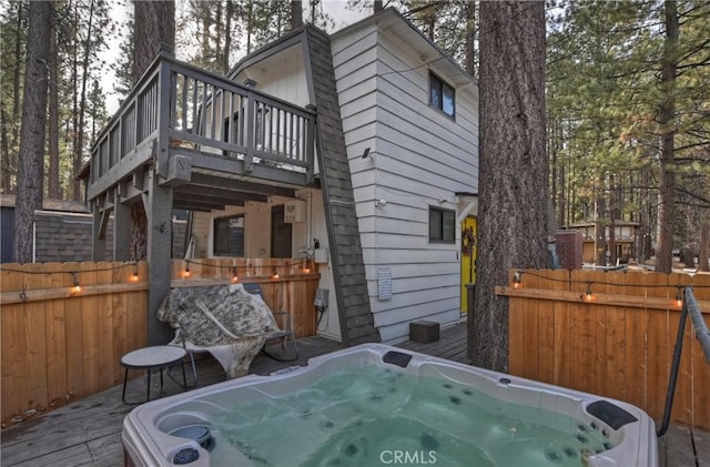 view of home's exterior with a hot tub and a wooden deck