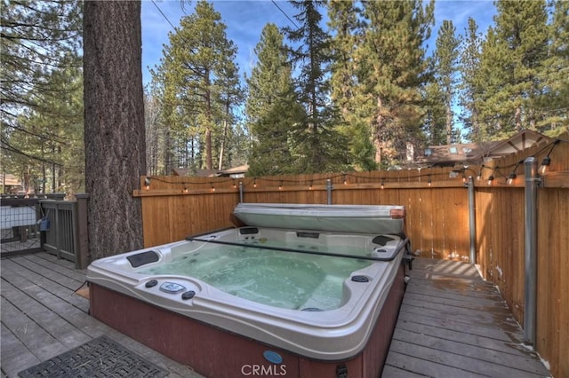 wooden deck featuring a covered hot tub