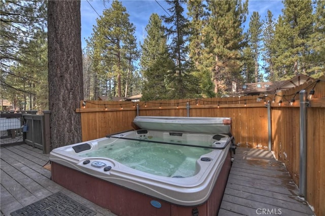 wooden terrace with fence and a covered hot tub