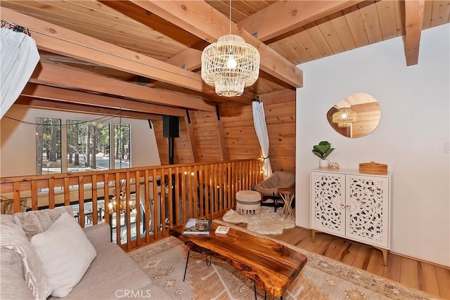 living area featuring an inviting chandelier, wood walls, light hardwood / wood-style flooring, and beamed ceiling