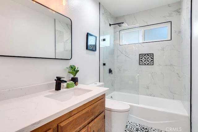 full bathroom featuring vanity, tiled shower / bath combo, and toilet