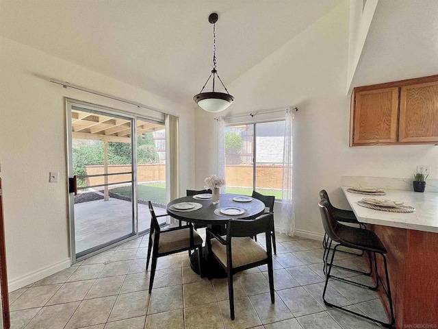 tiled dining area with vaulted ceiling