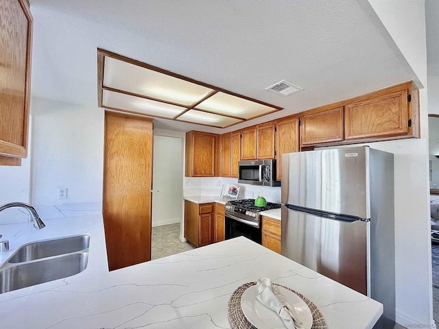 kitchen with appliances with stainless steel finishes, sink, and kitchen peninsula