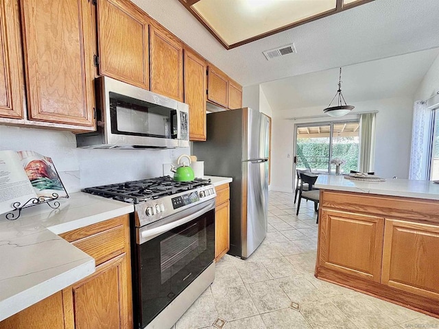 kitchen featuring appliances with stainless steel finishes, vaulted ceiling, hanging light fixtures, and light tile patterned floors