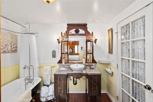 bathroom with wood-type flooring, a tub, and vanity