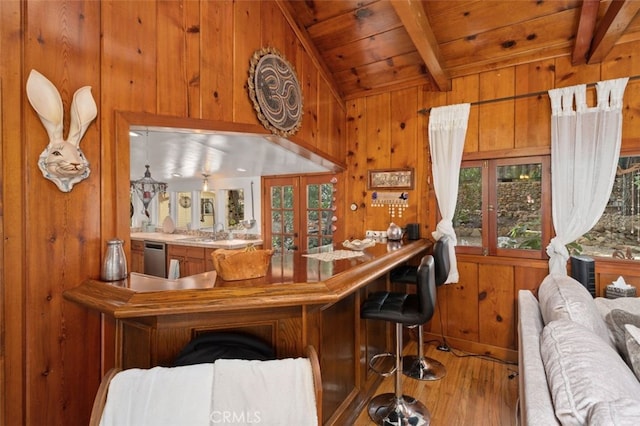 bar featuring wooden ceiling, plenty of natural light, wood-type flooring, and wood walls