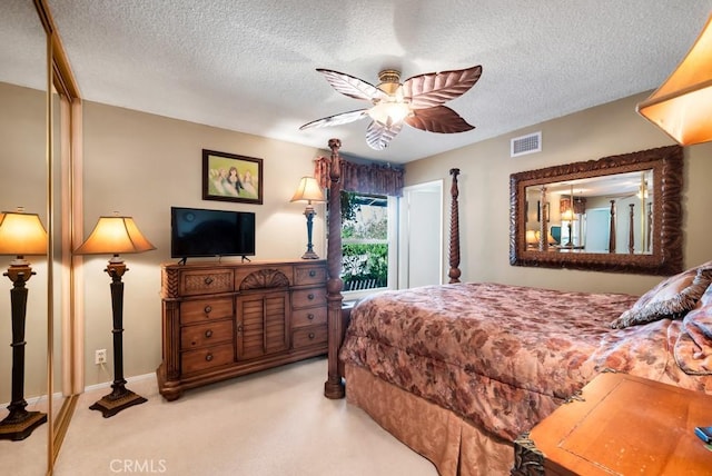 carpeted bedroom featuring a textured ceiling and ceiling fan