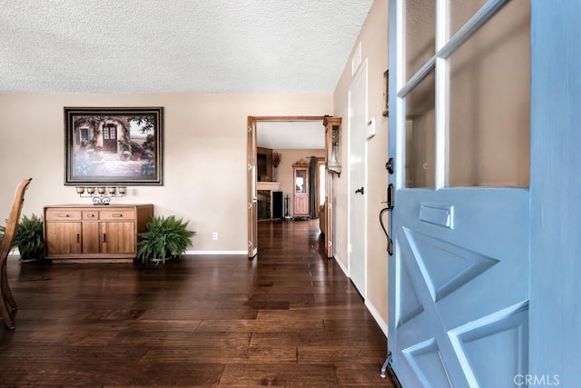 hallway with dark hardwood / wood-style floors and a textured ceiling