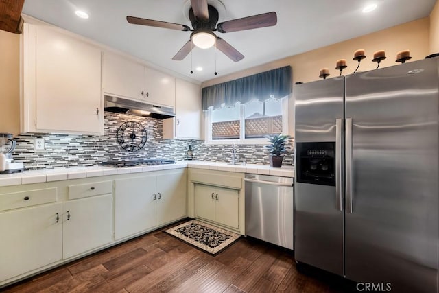 kitchen featuring white cabinetry, backsplash, tile countertops, and stainless steel appliances