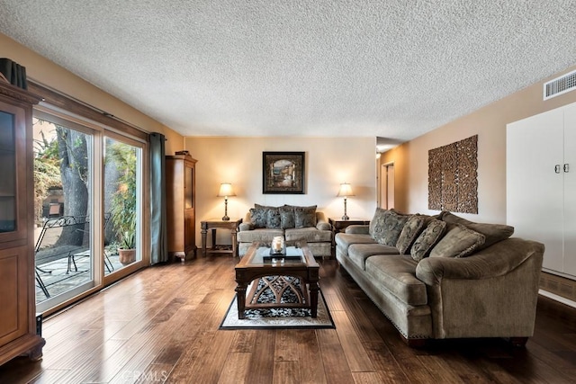 living room with dark hardwood / wood-style floors and a textured ceiling