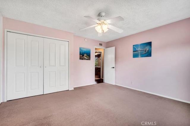 unfurnished bedroom featuring a textured ceiling, carpet floors, a closet, and ceiling fan