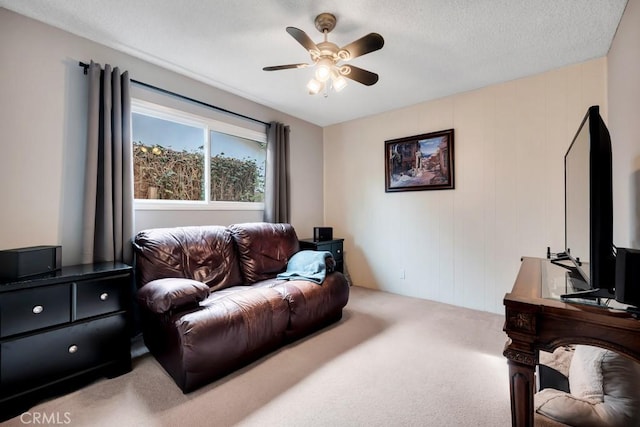 carpeted living room featuring ceiling fan and a textured ceiling