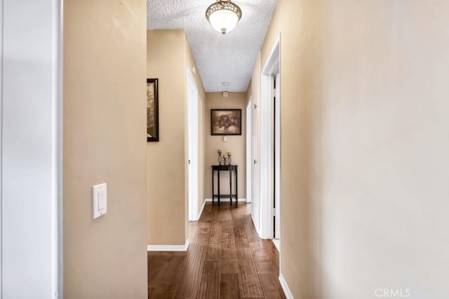 hall with dark hardwood / wood-style flooring and a textured ceiling