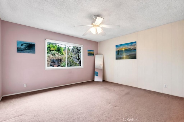 carpeted empty room featuring a textured ceiling and ceiling fan