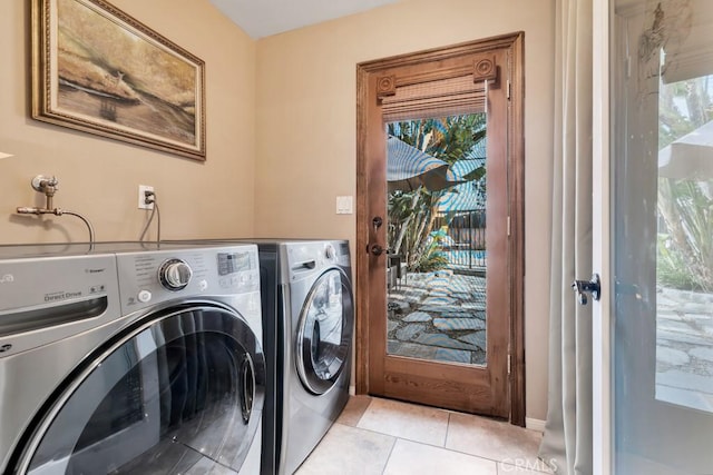 laundry room featuring washing machine and clothes dryer and light tile patterned flooring